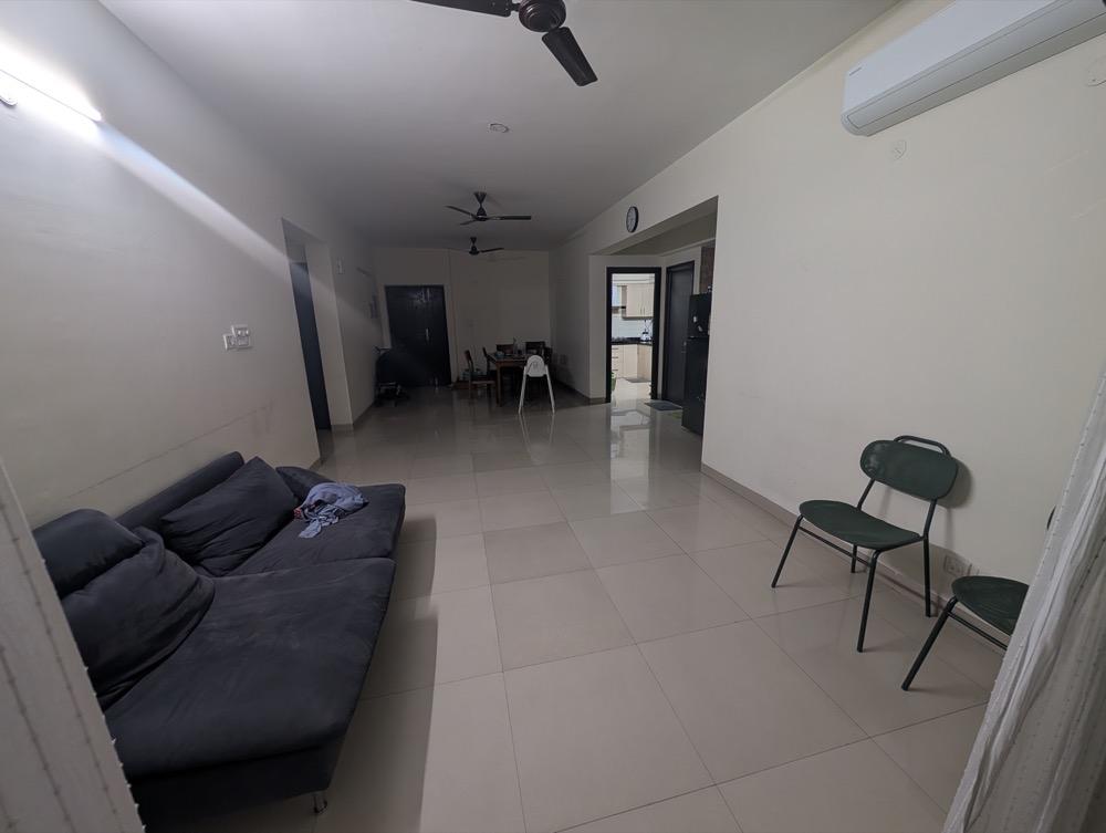 Existing long living room with wall-mounted tube lights and a separate kitchen entrance beyond